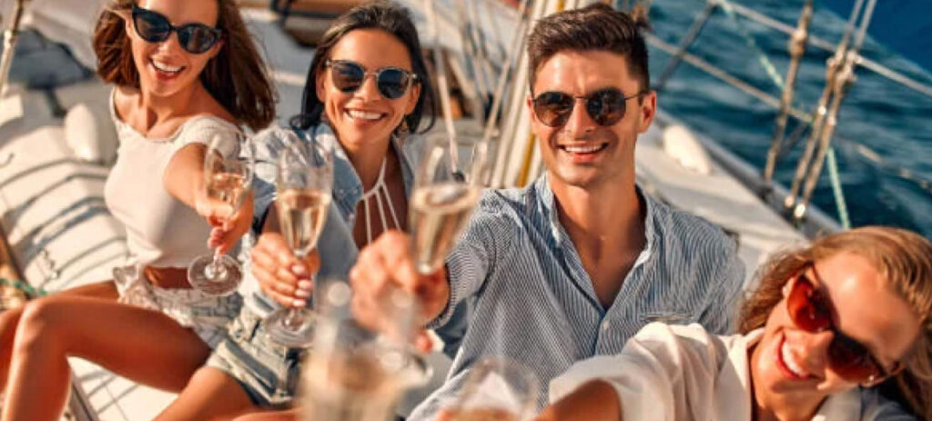 Grupa pracowników świętująca na rejsie firmowym z kieliszkami szampana.